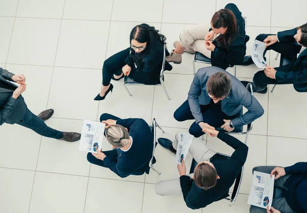 Vista superior. colegas de negócios apertando as mãos um com o outro na reunião. — Fotografia de Stock