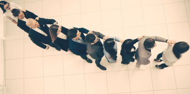 Üst Manzara. Bir grup iş adamı akıllı telefon ekranlarına bakıyor..