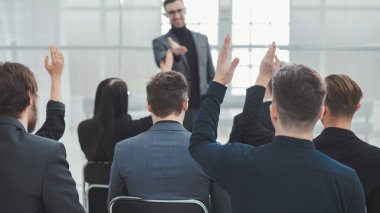 İş semineri sırasında çalışanlar konuşmacıya sorular soruyorlar.