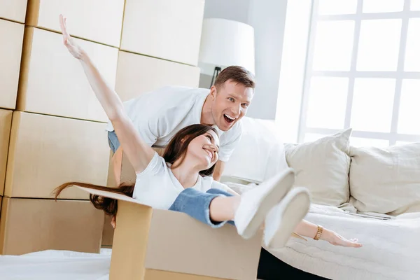 Husband and wife have fun unpacking boxes in their new apartment — Stock Photo, Image