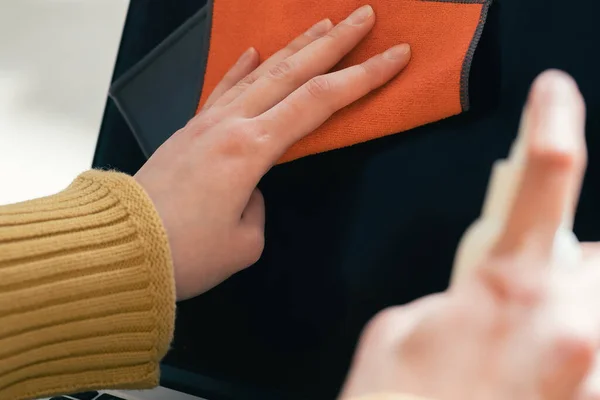 Nahaufnahme. eine junge Frau benutzt Antiseptikum, um ihren Laptop zu reinigen — Stockfoto