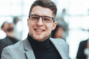 Ofiste duran kendine güvenen bir iş adamı.