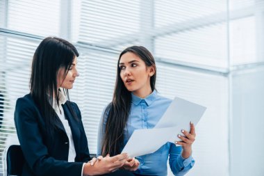 İki genç çalışan iş belgelerini tartışıyor. fotokopi alanı ile fotoğraf