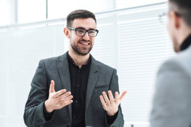 Çekici genç bir çalışan bir meslektaşına fikirlerini açıklıyor.