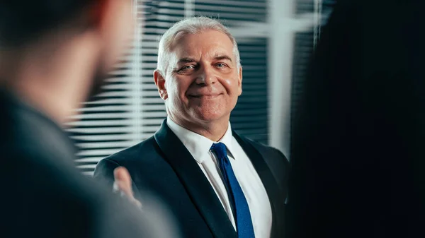 Successful businessman pointing to a flipchart with financial indicators — Stock Photo, Image