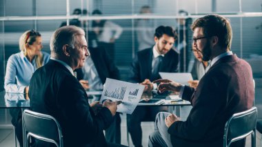 bir grup iş adamı mali belgeleri tartışıyor