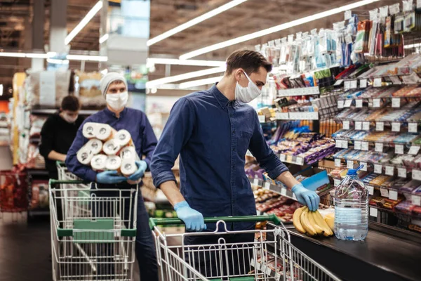 Groupe d'acheteurs dans des masques de protection debout près de la caisse dans un supermarché — Photo