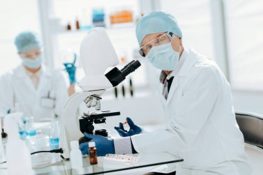 Kapat. Laboratuvar masasında oturan hırslı bir bilim adamı. .