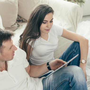 Yeni bir dairede aile fotoğrafı albümü olan genç bir çift..