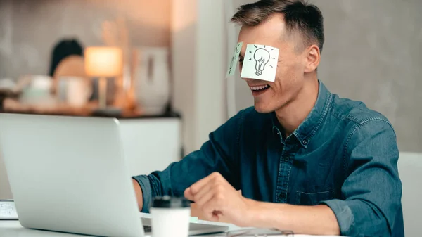 Jovem está trabalhando em um laptop e tem uma grande ideia. — Fotografia de Stock