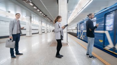 Metro yolcuları platformda treni bekliyorlar..