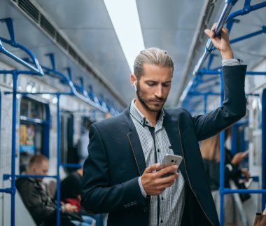 İşadamı metroda e-postalarını okuyor..