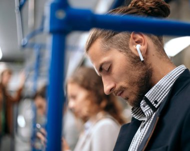 Yorgun iş adamı metro vagonunda uyur..