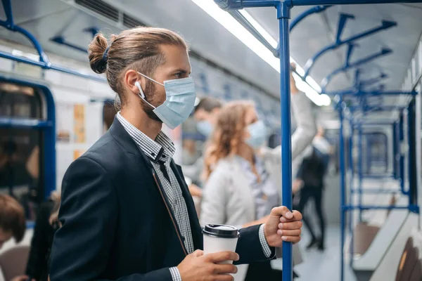 Metro vagonunda duran kahveli genç adam..