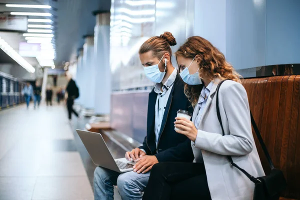 Junges Paar mit Laptop auf U-Bahn-Bahnsteig . — Stockfoto