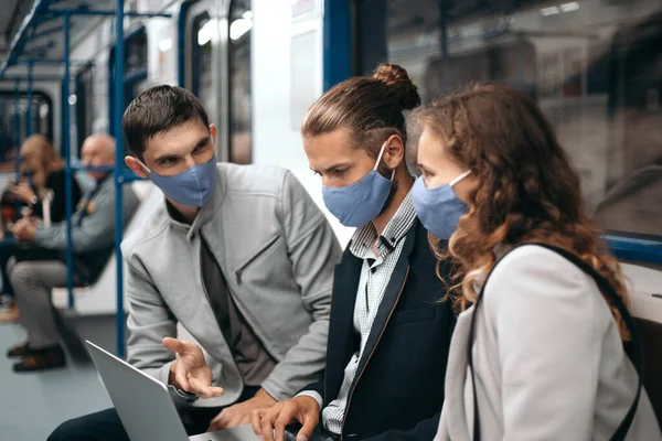 Groep jongeren die online nieuws bespreken terwijl ze in een metro zitten. — Stockfoto