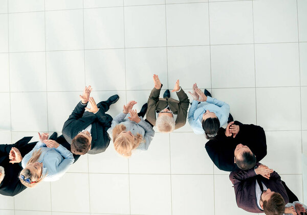 top view. business partners standing in front of a large group of employees.