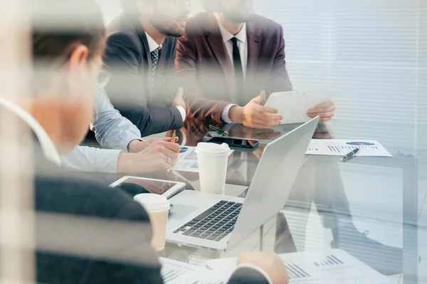 A través del vidrio. equipo de negocios sentado en el escritorio. — Foto de Stock