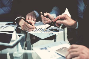 Kapat. İş arkadaşları mali tablolara bakıyor.