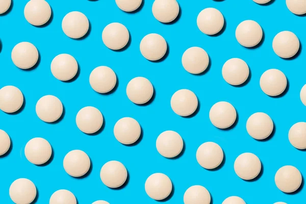 Lots of white pills on a blue background. — Stock Photo, Image