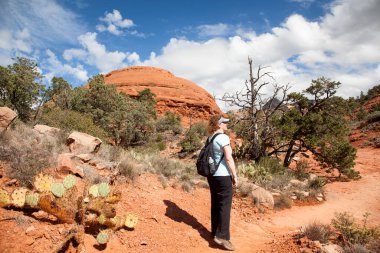 Sedona, Arizona 'daki Little Horse Patikası' nda çölde yürüyen bir kadın yürüyüşçü.