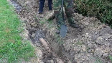 Drenaj hendek boru ile doldurmak gömmek için iki işçi