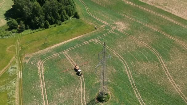 Jordbruk Traktor Besprutning Raps Fält Med Kemikalier Nära Hög Tower — Stockvideo