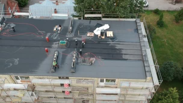 Workers repair old apartment flat house roof, aerial view — Stock Footage Workers Repair Old Apartment Flat House Roof Aerial View Royalty Free Stock Footage