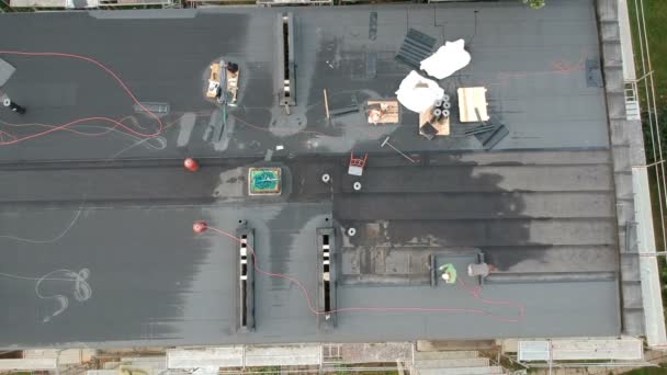Two workers repair waterproofing apartment flat house roof, aerial view — Stock Footage Two Workers Repair Waterproofing Apartment Flat House Roof Aerial View Stock Video