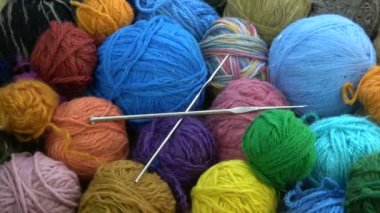 Birçok iplik yün topları iki metal örgü crotchets ile döner