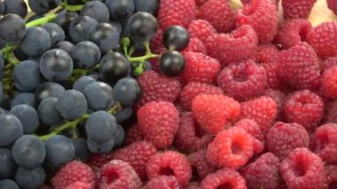 Dönen olgun ahududular ve kuzey üzümleri yiyecek arka planı