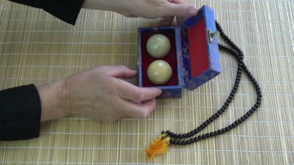 竹のマットの上にアジアの中国の手マッサージ大理石のボールと仏教ロザリオとオープンボックス — ストック動画