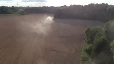 Tarım traktörü sonbaharda kuru tarlalara ekin ekiyor, havadan bakıyor.