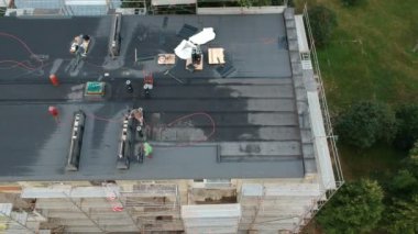 İki işçi onarım düz ev çatı City, havadan görünümü