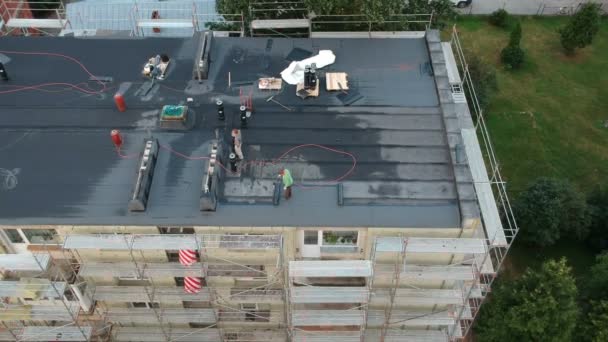 Workers roofers repair flat house roof in city, aerial view — Stock Footage Workers Roofers Repair Flat House Roof City Aerial View Royalty Free Stock Video