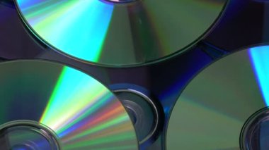 Parlak CD ve DVD diskleri arka planda dönüyor