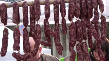 Vilnius, Litvanya Mart 2017: Vilnius Kaziukas fuarında geleneksel bahar el sanatları fuarı. Fuarda tütsülenmiş sosis koleksiyonu ve satıcısı, Vilnius, 4 Mart 2017