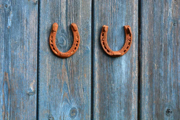 Dos herradura símbolo de la suerte oxidada en la vieja pared de madera granja — Foto de Stock