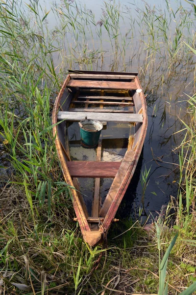 Дерев'яний старий рибальський човен на озері восени — стокове фото