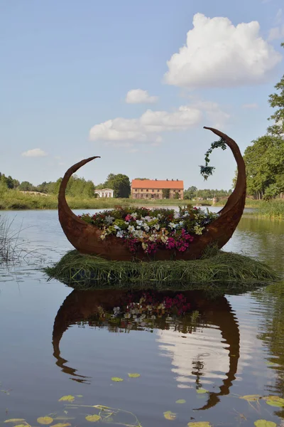 Decorative wooden boat full of flowers in manor park — Stock Photo, Image