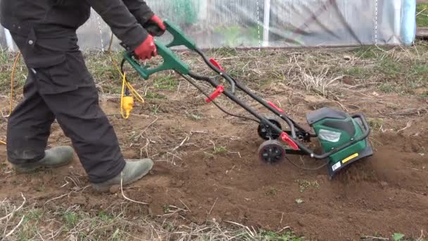 Jardineiro Solo Solo Arado Primavera Com Cultivador Elétrico Perto Estufa — Vídeo de Stock