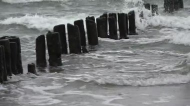 Harap olmuş ahşap direkler İskele yığınları ve fırtına dalgaları 