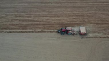 Kurumuş bahar tarlasına ekilen ekme makineli traktör, hava manzarası 