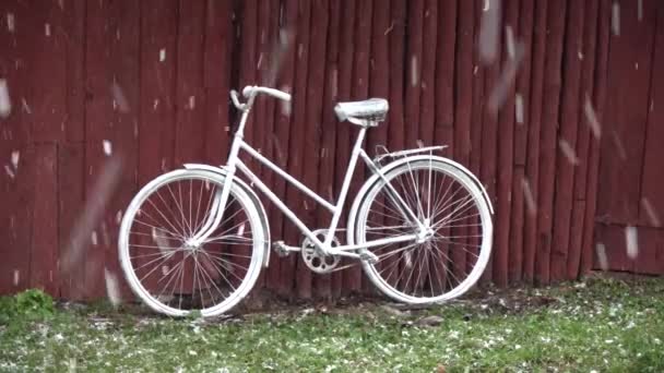 农场和暴风雪中靠近谷仓的旧白色装饰自行车 — 图库视频影像