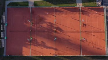 Tenis oyuncuları akşam sahasında oynuyor, hava görüşü