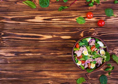 Ton balığı, domates, bıldırcın yumurtası, kuşkonmaz ve ahşap zemin üzerine soğan salatası