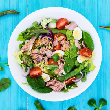 Ton balığı, domates, bıldırcın yumurtası, kuşkonmaz ve ahşap zemin üzerine soğan salatası