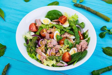 Ton balığı, domates, bıldırcın yumurtası, kuşkonmaz ve ahşap zemin üzerine soğan salatası