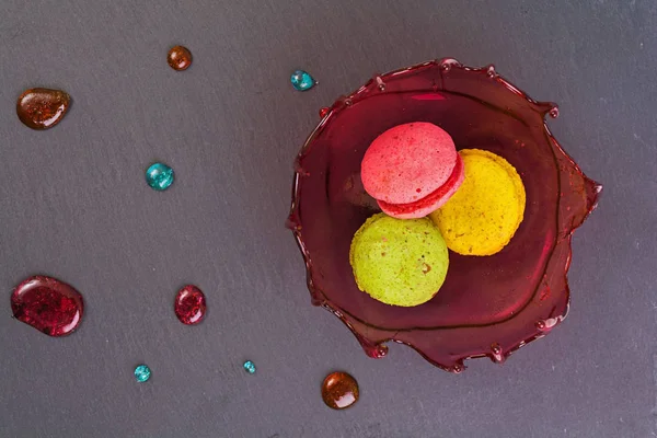 Şekerli tatlı ve ahşap zemin üzerine karamel kabın içinde macaron