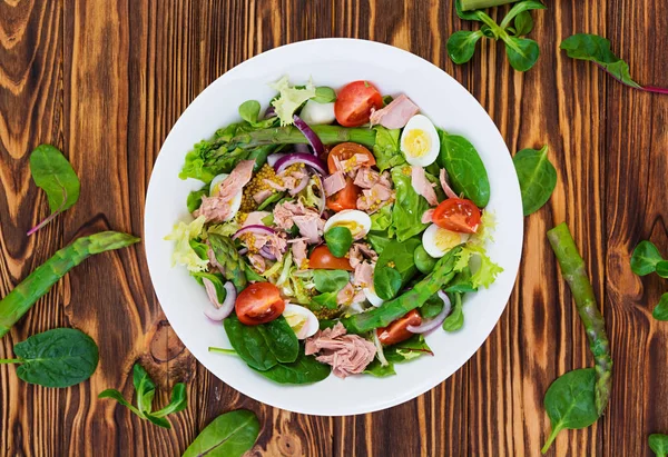 Ton balığı, domates, bıldırcın yumurtası, kuşkonmaz ve ahşap zemin üzerine soğan salatası